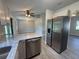 Kitchen view highlighting granite counters, stainless steel refrigerator, and adjacent dining area at 11681 Se 72Nd Court Rd, Belleview, FL 34420