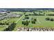 Expansive aerial view of a residential neighborhood with lush greenery and a clear blue sky at 12407 Ne 48Th Loop, Oxford, FL 34484
