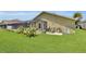 Lush backyard featuring a screened-in lanai, tropical plants, and exterior of house at 12407 Ne 48Th Loop, Oxford, FL 34484