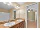 Bathroom with double sink vanity and an attached toilet and shower area at 12407 Ne 48Th Loop, Oxford, FL 34484
