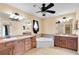 Spacious bathroom featuring dual vanities, a ceiling fan, and corner soaking tub at 12407 Ne 48Th Loop, Oxford, FL 34484