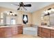 Bathroom featuring a soaking tub, double sinks, vanity, and large mirrors at 12407 Ne 48Th Loop, Oxford, FL 34484