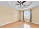 Bedroom features include a ceiling fan, tray ceiling, and a window with blinds at 12407 Ne 48Th Loop, Oxford, FL 34484
