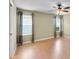 Empty bedroom with hardwood floors and two windows with curtains at 12407 Ne 48Th Loop, Oxford, FL 34484