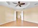 Bedroom with ceiling fan, laminate flooring, and double doors leading to another room at 12407 Ne 48Th Loop, Oxford, FL 34484