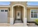 Welcoming front entryway with an arched porch and a decorative glass door at 12407 Ne 48Th Loop, Oxford, FL 34484