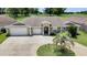 Beautiful home with a three-car garage, mature landscaping, and a circular driveway leading to a covered entrance at 12407 Ne 48Th Loop, Oxford, FL 34484