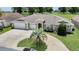 A well-maintained residence with a three-car garage, neat landscaping, and a charming circular driveway at 12407 Ne 48Th Loop, Oxford, FL 34484