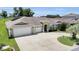 Charming single-story home featuring a three-car garage, landscaped yard and a welcoming front entrance at 12407 Ne 48Th Loop, Oxford, FL 34484