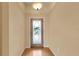 Inviting foyer featuring light-colored walls, wood flooring and a front door with decorative glass insert at 12407 Ne 48Th Loop, Oxford, FL 34484