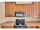 Close-up of kitchen appliances including an electric range and a microwave, plus wood cabinetry at 12407 Ne 48Th Loop, Oxford, FL 34484
