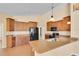 Bright kitchen featuring wood cabinets, a black refrigerator, and a granite countertop at 12407 Ne 48Th Loop, Oxford, FL 34484