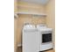 Functional laundry area with a washer, dryer, and wire shelving at 12407 Ne 48Th Loop, Oxford, FL 34484