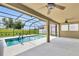 Screened-in pool with covered patio and ceiling fans overlooking the backyard at 12407 Ne 48Th Loop, Oxford, FL 34484