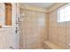 Tiled walk-in shower with a built-in seat and adjustable shower head at 12407 Ne 48Th Loop, Oxford, FL 34484