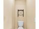 Powder room showing toilet and decorative rack on a textured wall at 12407 Ne 48Th Loop, Oxford, FL 34484