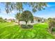Backyard featuring lush green grass, a stone pathway, and mature landscaping at 1401 Madrigal Ln, Lady Lake, FL 32159