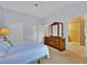 Bright bedroom with a double bed, large closet and dresser, leading into an ensuite bathroom at 1401 Madrigal Ln, Lady Lake, FL 32159