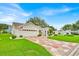 Charming home with mature landscaping and a patterned driveway at 1401 Madrigal Ln, Lady Lake, FL 32159