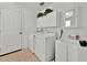 Functional laundry room with a washer, dryer, sink, and storage cabinets, designed for efficiency at 1401 Madrigal Ln, Lady Lake, FL 32159