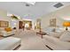 Spacious living room featuring neutral tones, a ceiling fan, and a view into the dining area at 1401 Madrigal Ln, Lady Lake, FL 32159