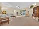 Bright living room with neutral carpeting, ceiling fan, and sliding glass doors at 1401 Madrigal Ln, Lady Lake, FL 32159