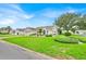 Well maintained front yard featuring manicured lawn, landscaping, and white single-story home at 1401 Madrigal Ln, The Villages, FL 32159