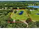 Aerial view of the property features the pond surrounded by green pastures and mature trees at 14325 Manchester Ave, Groveland, FL 34736
