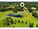 Aerial view reveals the serene pond, surrounded by lush landscapes, on this expansive property at 14325 Manchester Ave, Groveland, FL 34736