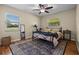 Cozy bedroom with hardwood floors, ceiling fan, and bright windows offering a pleasant view at 14325 Manchester Ave, Groveland, FL 34736