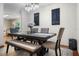 This elegant dining room features a modern chandelier and dark wood table with bench seating at 14325 Manchester Ave, Groveland, FL 34736