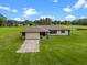 Attractive single-story home with a garage and picturesque, expansive green lawn under a bright sky at 14325 Manchester Ave, Groveland, FL 34736