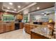 Well-lit kitchen featuring granite counters, custom wood cabinets, and an open view to the living room at 14325 Manchester Ave, Groveland, FL 34736
