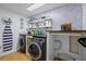 Well-organized laundry room with modern washer and dryer, shelving, and stylish decor at 14325 Manchester Ave, Groveland, FL 34736