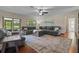Bright living room with hardwood floors, a comfortable couch, and sliding glass doors to the backyard at 14325 Manchester Ave, Groveland, FL 34736
