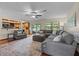 Spacious living room featuring an oversized couch, hardwood floors, and lots of natural light at 14325 Manchester Ave, Groveland, FL 34736