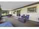 Covered patio with comfortable seating and tranquil view of the backyard and pond at 14325 Manchester Ave, Groveland, FL 34736