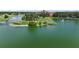 Beautiful aerial view of a tranquil lake with a golf course and resort in the background at 1512 Cervantes Pl, Lady Lake, FL 32159