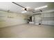 Spacious two car garage with epoxy flooring, storage, and utility sink at 1512 Cervantes Pl, Lady Lake, FL 32159