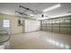 Spacious garage with epoxy flooring, storage cabinets, and an automatic door at 1512 Cervantes Pl, Lady Lake, FL 32159