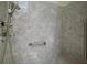 Modern walk-in shower features updated showerhead, safety bar, and stylish marble design at 1512 Cervantes Pl, Lady Lake, FL 32159