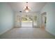 Sun room with neutral carpet, light paint, chandelier, and double doors leading outside at 1512 Cervantes Pl, Lady Lake, FL 32159
