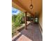 Covered front porch with brick pavers, decorative columns, and hanging lights at 17329 Se 115Th Ter, Summerfield, FL 34491