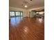 View of the living room with wood floors and view into kitchen at 17329 Se 115Th Ter, Summerfield, FL 34491