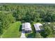 Scenic aerial view of the property showcasing lush greenery, metal roof, and convenient carport at 1855 Stacey Dr, Mount Dora, FL 32757
