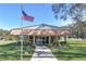 Inviting community clubhouse with a manicured lawn and American flag at 1855 Stacey Dr, Mount Dora, FL 32757