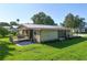 Charming home featuring a metal roof, deck, screened porch, and lush green lawn at 1855 Stacey Dr, Mount Dora, FL 32757