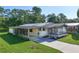 Charming single-story home with a metal roof, screened porch, and a well-maintained front lawn at 1855 Stacey Dr, Mount Dora, FL 32757