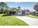 Well-maintained home with a long driveway, screened porch, and lush lawn, offering great curb appeal at 1855 Stacey Dr, Mount Dora, FL 32757