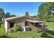 Charming home exterior with wood siding, manicured lawn, and covered deck at 1855 Stacey Dr, Mount Dora, FL 32757